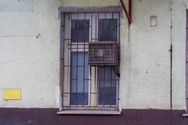 Parmaklıklı pencereli eski bina girişi ve kentsel mimari ve güvenlik özelliklerini gösteren yıpranmış cephe