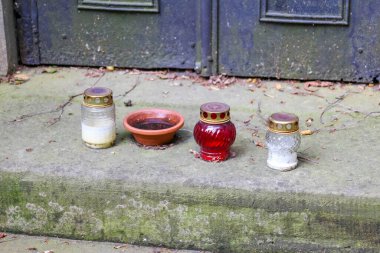 Anma mumları ve çiçekler haraç olarak beton zemine konuldu.