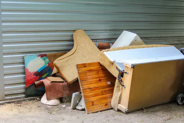 Atılmış karton kutular ve ev eşyaları binanın dış duvarına saçılmış.