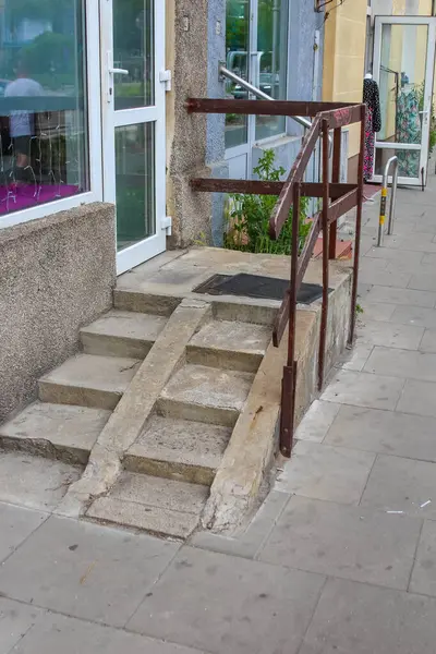 Ahşap merdiven bina duvarına yaslanmış beton basamaklar ve kentsel yerleşim geçmişiyle gündüz vakti