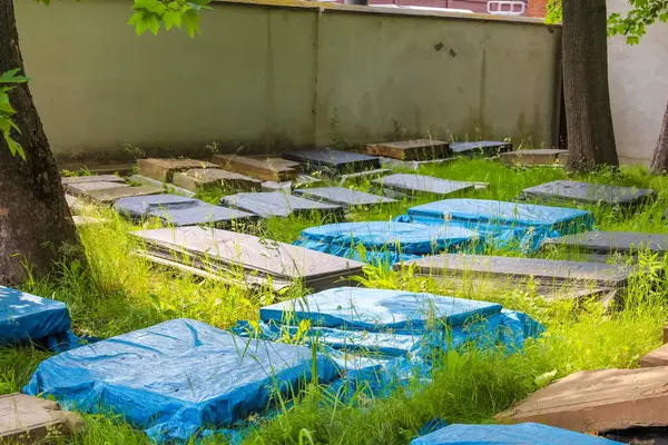 Bakım ve hava koruması sırasında mezarlıktaki mezarlıkları kaplayan mavi koruyucu muşambalar.