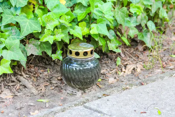 Bahçenin ve yeşilliğin yanındaki çakıllı zemine konmuş mumlu fener.