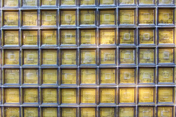 Şeffaf cam blok bir duvar yakın çekim ızgara desenli, soyut bir arkaplan dokusu oluşturur.