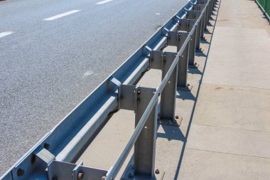 Bulutlu gökyüzüne karşı çapraz destek kirişleriyle modern çelik köprü inşaatı geometrik mimari desen oluşturur