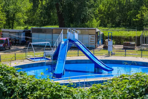 Açık hava eğlence parkı ortamında renkli kaydırak ve sıçrama özellikleri olan çocuk su oyun parkı