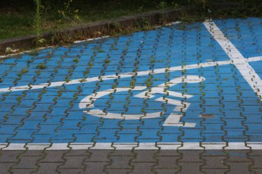 İnşaat alanını kaplayan mavi koruyucu plastik kaplama beton kaldırımda uyarı bandıyla kaplı.