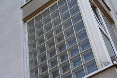 Yansıtıcı pencerelerle modern cam ofis cephesinin yukarı doğru perspektifi geometrik desen oluşturur