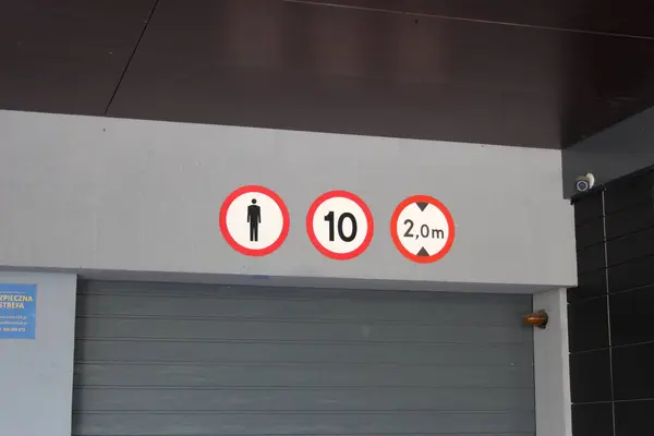 Kısıtlı erişim ve yükseklik sınırlamalarını gösteren kırmızı trafik uyarı işaretli garaj girişi