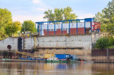 Sakin nehir suyunun yanında yükleme limanı ve kamyonu olan sanayi bölgesi.