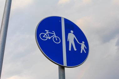 Paylaşılan yol tanımlaması için bisiklet ve yaya sembollerini gösteren mavi dairesel trafik işareti