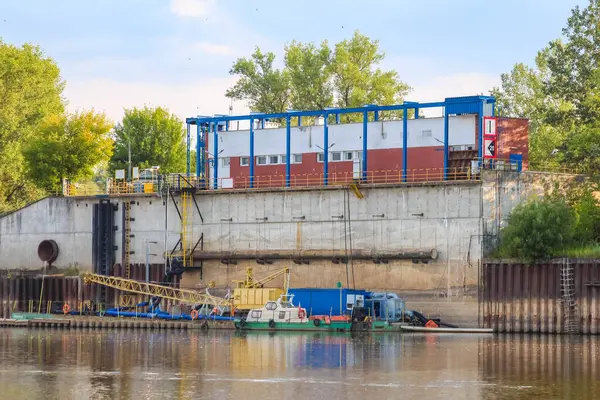 Sakin nehir suyunun yanında yükleme limanı ve kamyonu olan sanayi bölgesi.