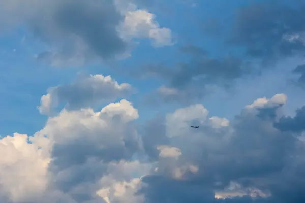 Şişkin beyaz kümülüs bulutlarıyla dolu dramatik mavi gökyüzü çarpıcı bir doğal bulut deseni yaratıyor.