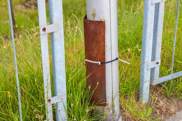 Kentin çevresinde doğal olarak büyüyen yeşil çimenli beyaz metal çit direkleri