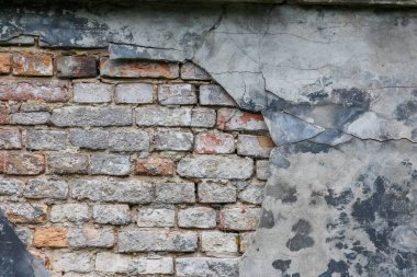 Tarihi mezarlık mimarisi detaylarında doğal yıpranma ve doku bozulmasını gösteren soyulmuş alçılı eski tuğla duvar.