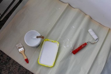 Boya silindiri ve beyaz boyalı tepsi duvar boyası ve tadilat için hazır.