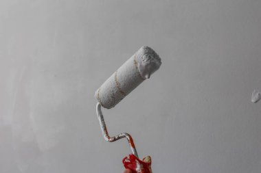 İnşaat reklamı için minimalist gri arka planda çapraz konuma yerleştirilmiş ahşap saplı boya silindirinin yakın çekim görüntüsü