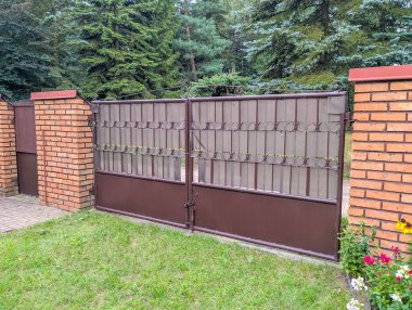 Tuğla ve ahşap çit kombinasyonu banliyö mülkünde sofistike konut çizimi yaratıyor