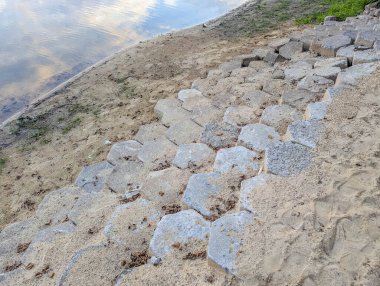 Düzenli sıralarda sıralanmış beton bloklar inşaat veya peyzaj projesi için geometrik desen oluşturuyor