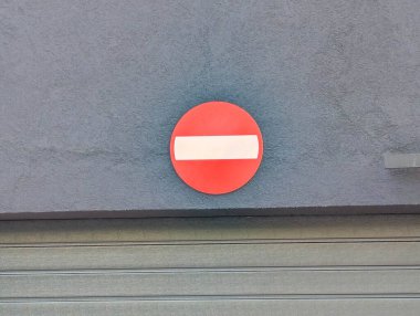 Kentsel sokak ortamında beton duvara asılmış giriş trafik levhası yok