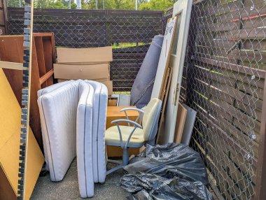 Eski beyaz radyatörler ve ısıtma ekipmanları toplanmak için konut binasının dışına bırakılmış.