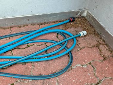 Profesyonel kurulum sürecinde telekomünikasyon ekipmanlarını gösteren tuğla yüzeyde düzenlenmiş mavi fiber optik kablolar