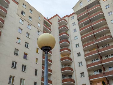 Upward view of modern residential apartment building showing architectural details with balconies and contemporary facade design