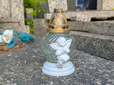 White angel figurine statue positioned on concrete cemetery base with peaceful spiritual presence and memorial significance
