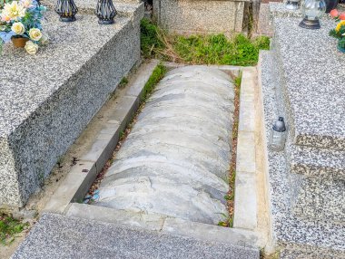 Long stone cemetery monument with smooth granite surface and decorative elements showcasing traditional memorial architecture and craftsmanship
