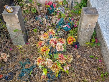 Warsaw, Poland, June 16, 2025 Fresh floral arrangement with colorful blooms brightens weathered stone grave creating vibrant memorial tribute