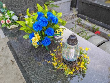 Warsaw, Poland, June 16, 2025 Vibrant blue and yellow flower arrangement creates striking colorful memorial tribute display in cemetery setting