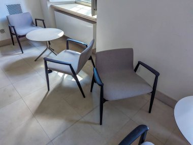 Modern çalışma ortamında cilalı beton zemine yerleştirilmiş metal çerçeveli çağdaş ofis sandalyeleri