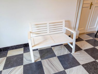 Klasik iç tasarımda siyah beyaz kareli mermer zemin üzerinde duran geleneksel beyaz kolon radyatörü