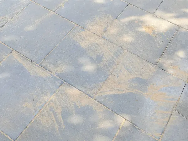 Beton kaldırım üzerine dökülen geometrik gölge desenleri soyut aydınlık ve karanlık bileşim oluşturur