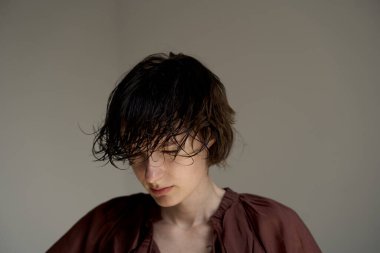 Burgundy süveter giyen, saçı doğal ışıklandırma yaşam tarzı portresi olan genç bir adam.