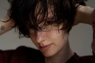 Saçları dağınık, gözleri derin derin aydınlatma portresiyle kaplanmış genç bir adam.