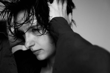 Siyah-beyaz bir insan portresi. Siyah-beyaz bir süveter ve aşağı doğru bakan bir bakış ve sanatsal kompozisyon.