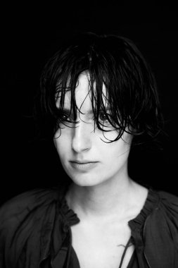 Monokrom moda portresi desenli giysiler içinde dramatik koyu arkaplan ve aydınlatma