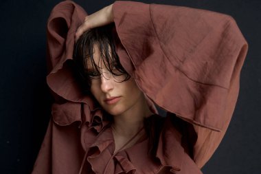 Islak saçlı, bordo kapüşonlu bir kapüşonlu giyen genç adam özel bir portrede çekilmiş.