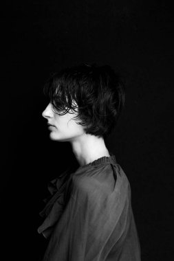 Sanatsal yan aydınlatma ve gölge oyunlarıyla süveter giymiş tek renkli kadın portresi