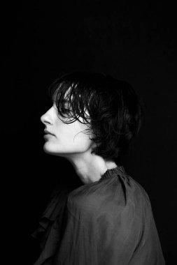 Umut dolu bir ifade ve dramatik bir kontrastla yukarı bakan siyah beyaz kadın portresi