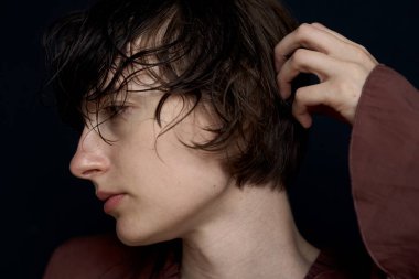 Saçı dağınık ve doğal ışıklandırmalı genç bir kadının yakın plan portresi.