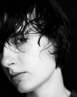 Islak desenli saçlı, duygusal hassasiyet ve güç gösteren tek renkli kadın portresi.