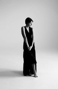 Modern mimari arkaplana karşı sofistike siyah elbiseli profesyonel moda fotoğrafçılığı.