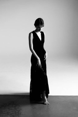 Akan siyah elbisedeki profesyonel model stüdyo fotoğraf çekimi sırasında dinamik siluet oluşturur