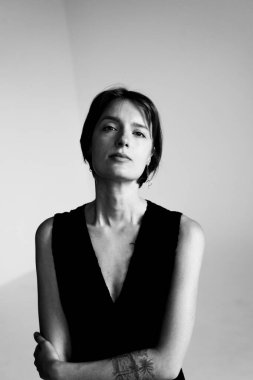 Etkileyici siyah beyaz stüdyo ışıklarıyla çekilen sakin yüzlü genç bir kadının yakın plan portresi.