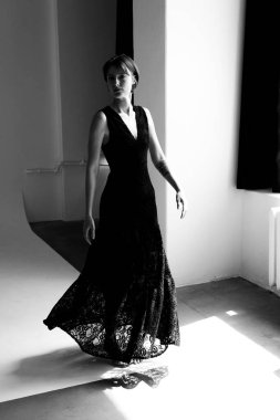 Siyah dantel elbiseli manken, beyaz geometrik stüdyo mimarisine karşı sanatsal siluet oluşturuyor.