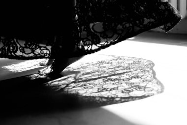 Detaylı siyah dantel malzeme parlak doğal ışık altında sıcak ahşap yüzey üzerine karmaşık dekoratif gölgeler dökme