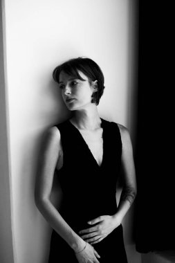 Siyah yelekli zarif bir kadının profesyonel portresi beyaz stüdyo arkaplanına karşı dramatik ışıklandırmayla