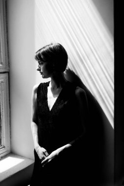 Siyah kıyafetli zarif bir kadının profesyonel moda portresi dikkat çekici doğal ışık ve gölge etkileşimi