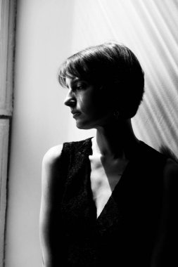 Mükemmel ışıklandırması ve modern stili olan sofistike siyah elbiseli bir kadının zarif stüdyo portresi.